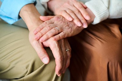Hands of two people gently holding each other in a gesture of support and companionship